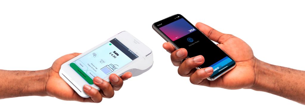 Person making a contactless payment using a card machine at a small business.