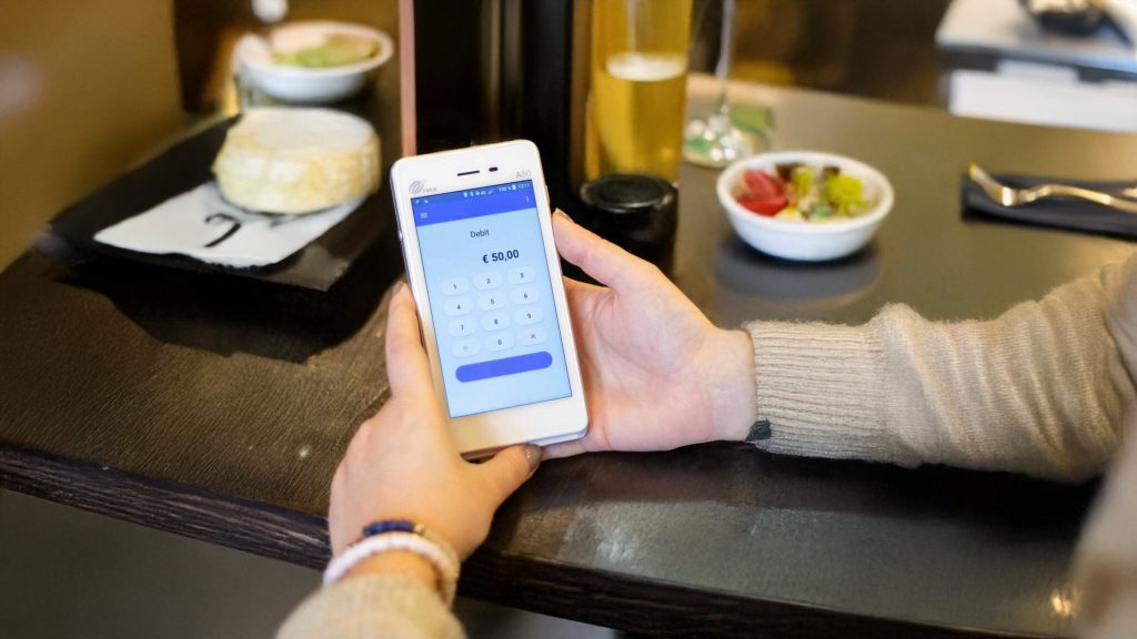 Restaurant payment processor comparison showing customer making contactless payment at tableside
