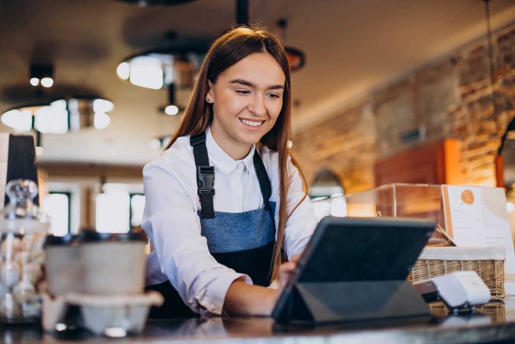 Waiter using retail EPOS Ireland tablet system on restaurant counter showing restaurant POS systems functionality - Compayre.ie