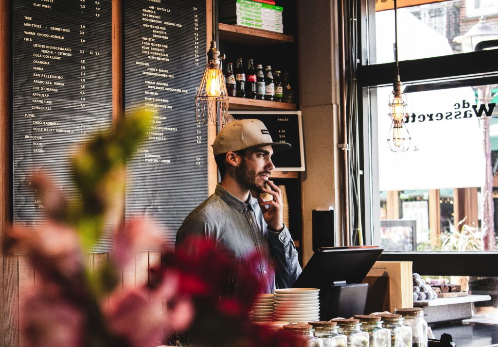 Barista at coffee shop counter processing payment with systems that prevent payment disputes Ireland