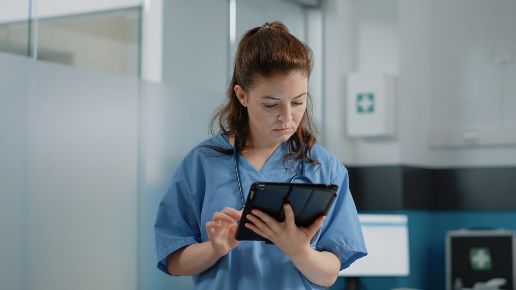 Health assistant using tablet for healthcare payments Ireland processing patient payment solutions in Irish medical practice