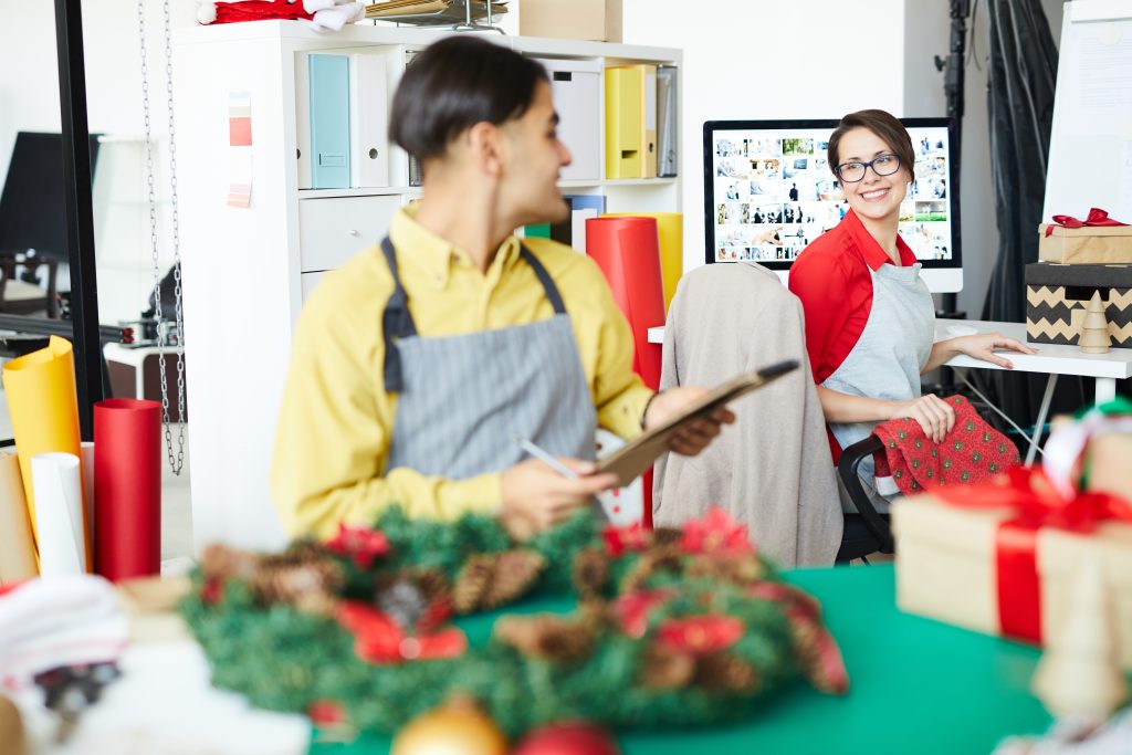 Store worker with tablet discussing Christmas payments Ireland capacity planning with business owner at counter during festive season