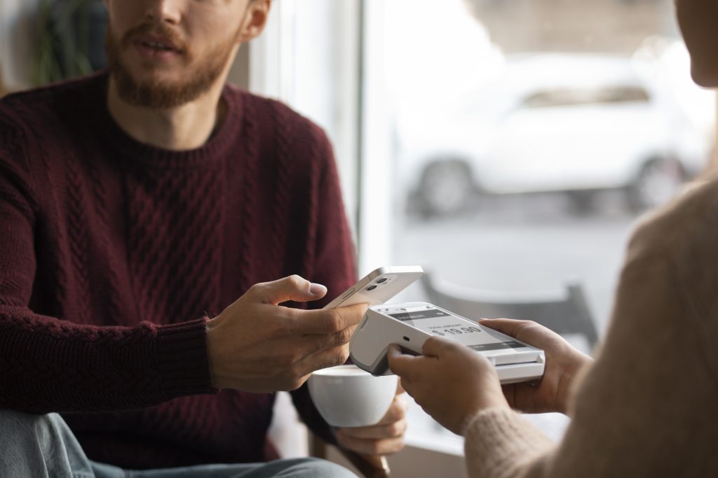 Customer making contactless payment on PAX A920 PRO terminal showing payment reconciliation Ireland transaction processing