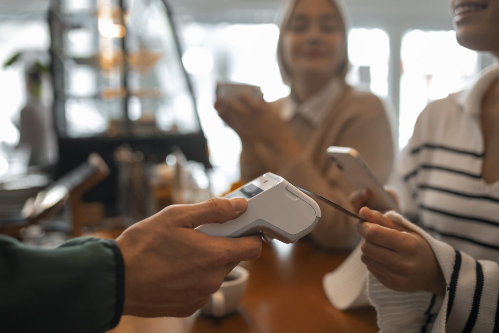 Customer making contactless payment showing merchant services insurance Ireland protection for payment fraud and data breach risks