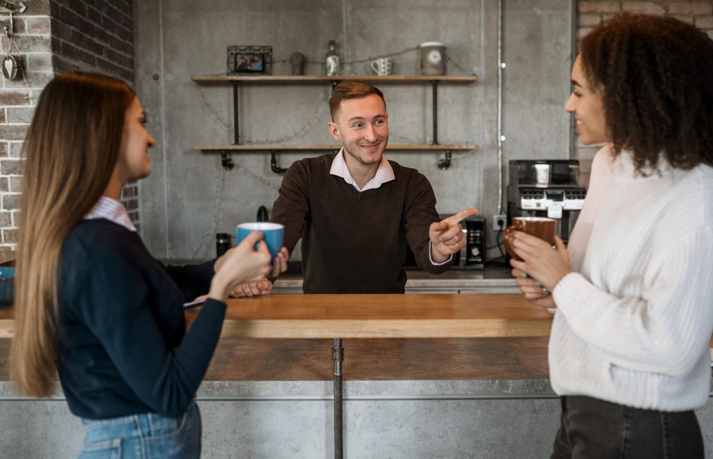 Business colleagues meeting at Irish coffee shop counter discussing chain store payments Ireland and multi-site merchant services strategy