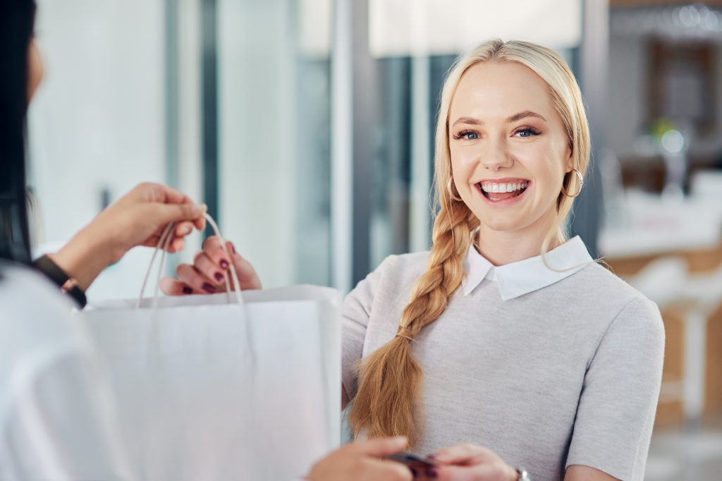 Happy woman holding shopping bags and credit card representing BNPL Ireland retailers offering Buy Now Pay Later payment options
