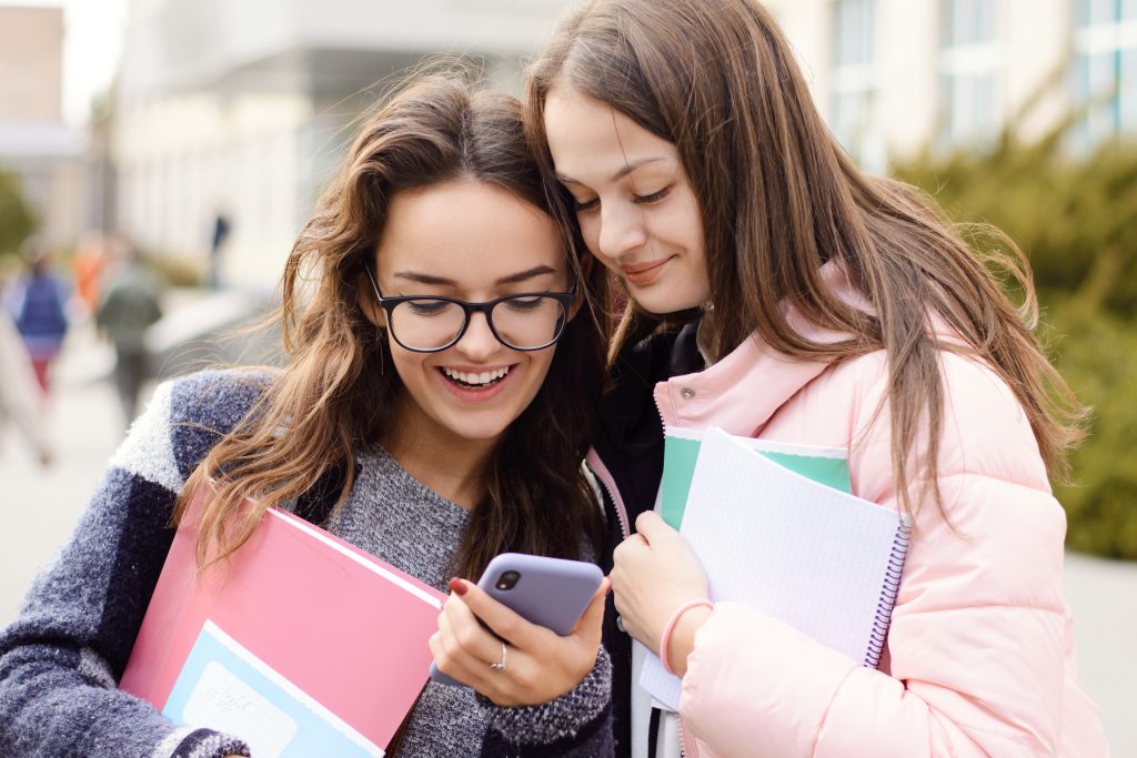 Two students holding notebooks representing education payments Ireland with school payment processing for fee collection and cafeteria systems