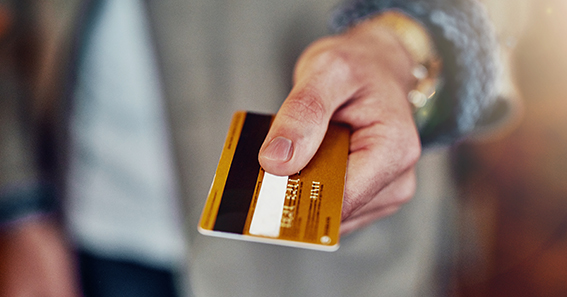 Person holding a debit card to pay at an Irish business with lower card processing fees Ireland