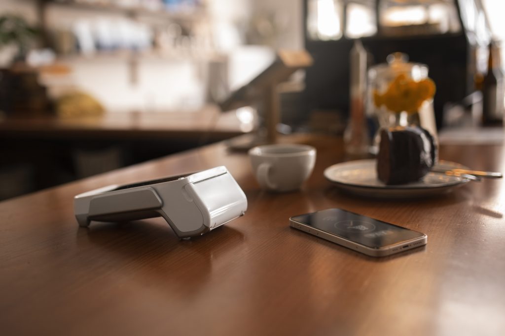 PAX A920 Pro card machine on a coffee shop counter ready to reduce card machine fees